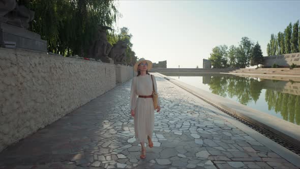 Attractive woman walking by the pond at the Memorial Complex in Volgograd alt