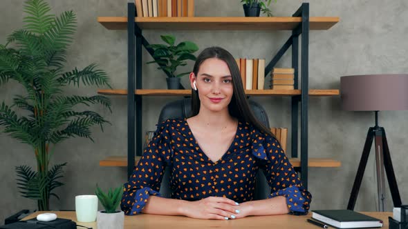 Smiling woman teacher sitting in home office looks camera listen student video conference call chat alt