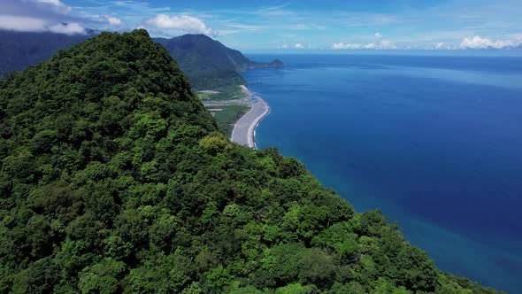 Flying over a lush Tropical mountain ridge to reveal the beautiful eastern coastline of Taiwan alt