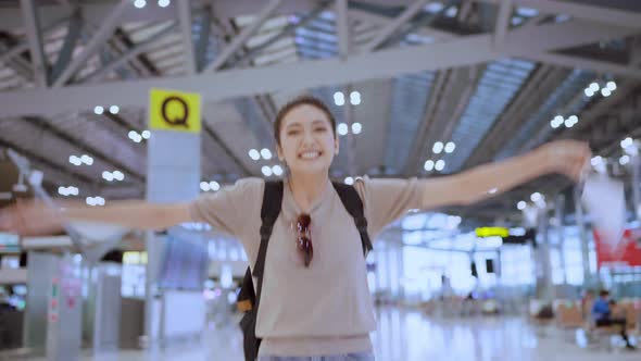happiness attractive traveller asian femlae casual cloth hand wave gesture smiling walking airport