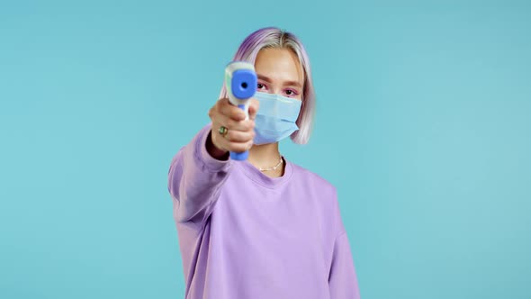 Woman in Protective Mask Directs Electronic Non-contact Thermometer Into Camera Lens and Measures alt