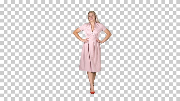 Woman in Dress with Hands on Hips Walking While Looking at Camera alt