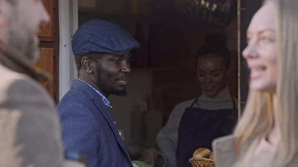 Young man buying coffee in food booth on the street