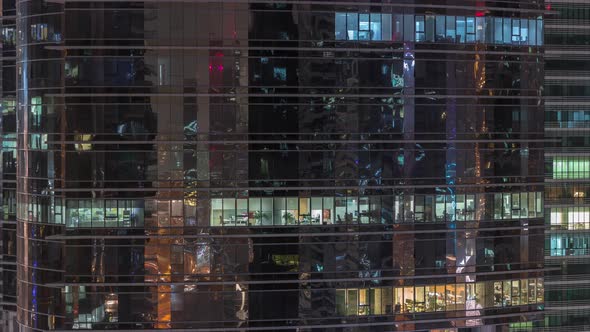 Office Skyscraper Exterior During Late Evening with Interior Lights on and People Working Inside alt