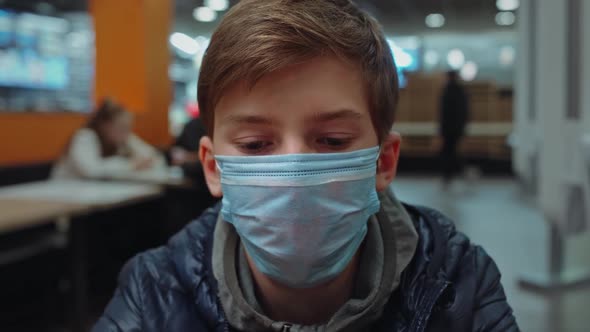 Closeup View Video Portrait of Young White Kid Wearing Medical Face Mask While Standing in Cafe
