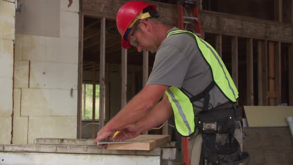 Construction worker cutting with circular saw