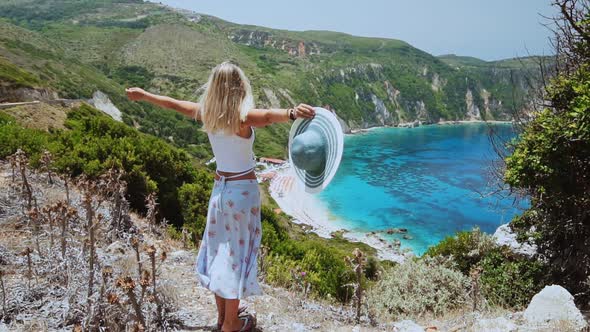 Slow Mo of Beautiful Blond Women Holding Sun Hat and Raising Her Hands on Vacation at Kefalonia alt