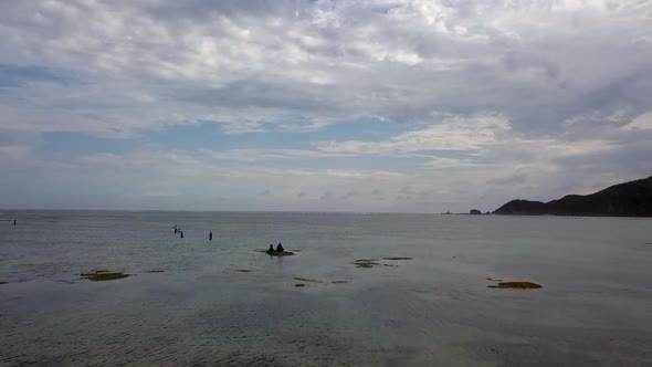 Slow motion over the reef at low tide with local fisherman.Stunning aerial view flight overfly dron alt
