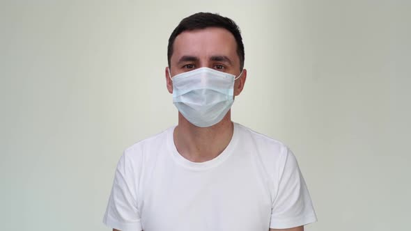 Scared Young Man in Medical Mask Suffocates in Front of the Camera. alt