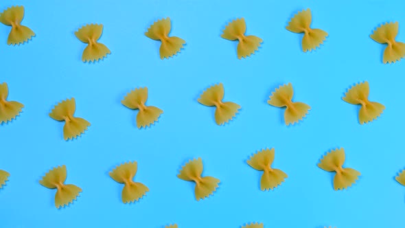 Rotating Background of Farfalle Pasta on a Blue Background