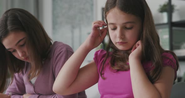 Woman helping children with their homework, they are sitting at desk and studying together