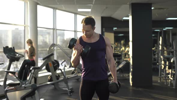 Male Bodybuilder Lifting Weight, Doing Dumbbell Curls, Morning Workout in Gym alt