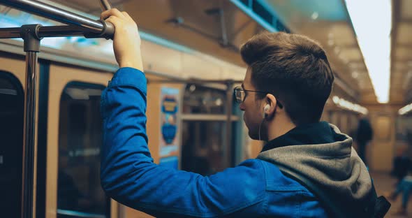 Passenger Rides While Standing in the Car and Holds on to the Rail alt