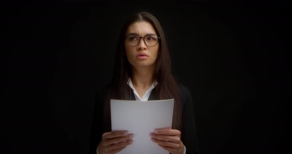 Businesswoman Reads a Document on a White Sheet of Paper Does Not Want to Work