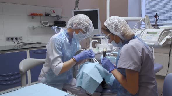 Close-Up Of Two Female Dentists Performing Surgery On A Patient's Teeth, Modern Dentistry alt