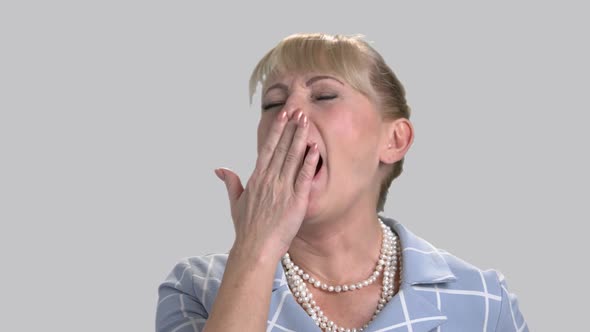 Sleepy Business Woman on Gray Background. alt