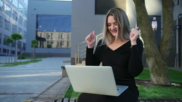 Attentive Woman Working on a Laptop Sitting Bench in the Street alt