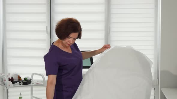 Cheerful Female Cosmetologist Preparing Her Office for Clients alt