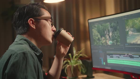 Asian Male Video Editor Works And Drinking Coffee With His Personal Computer, He Works Late At Night alt
