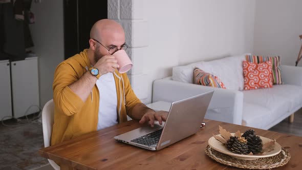 Young man working at home concentratedly with leptop.