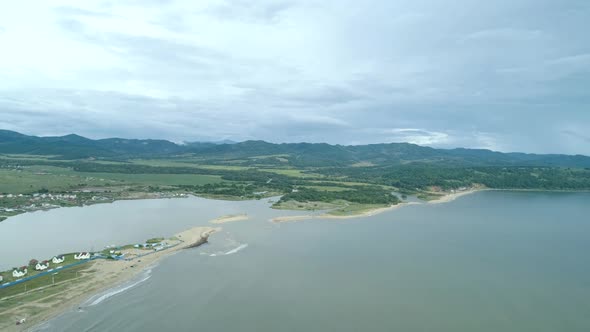 Aerial Shot Over the Sea in Summertime with Turquoise Water on Cloudy Day alt