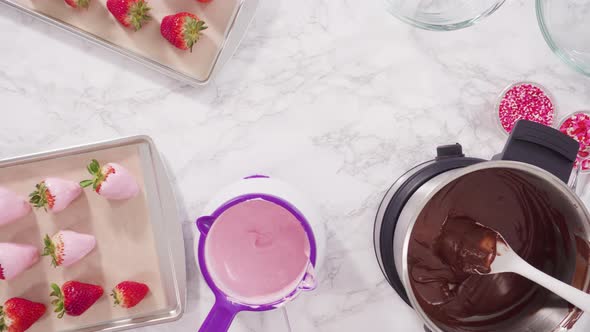 Flat lay. Step by step. Dipping organic strawberries into melted pink chocolate. alt