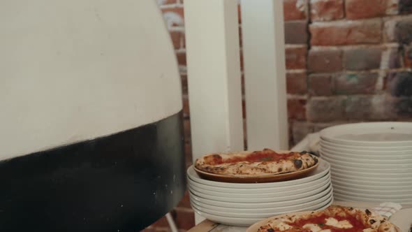 Chef In The Pizzeria Prepares A Pizza And Decorates It With Parmesan