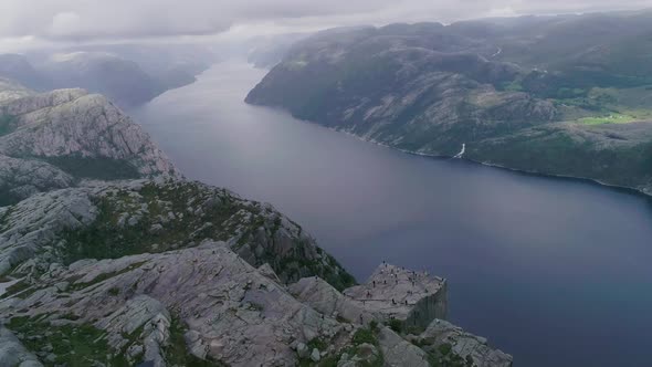 Aerial Slomo Drone shot of Preikestolen, Norway, with Tourists Walking and Photographing. alt