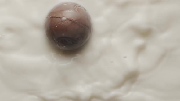 Round Chocolate Falling Into a Milk Bowl and Making Crown and Circular Ripples alt