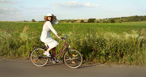 Happy Woman Riding Bicycle on Country Road