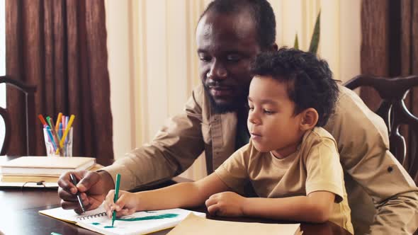 African American man teaching his son to draw