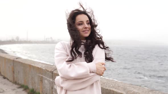 Attractive happy woman standing on the coast. alt