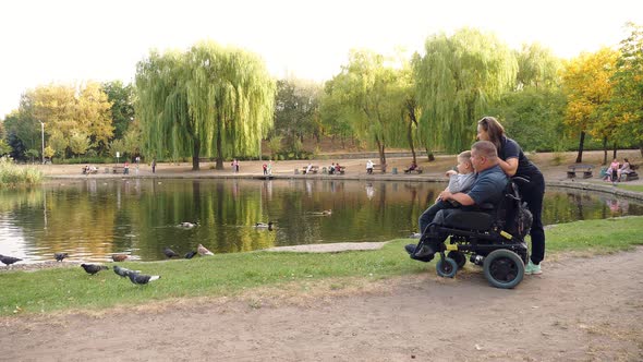 Wheelchair Man. Handicapped Man. Young Disabled Man Sits in Wheelchair, Surrounded By His Family alt