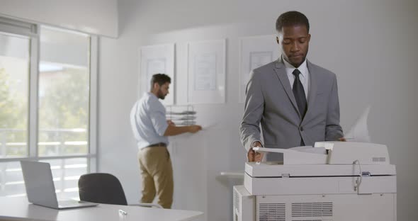 Afroamerican Businessman Operating Copy Machine in Modern Office alt