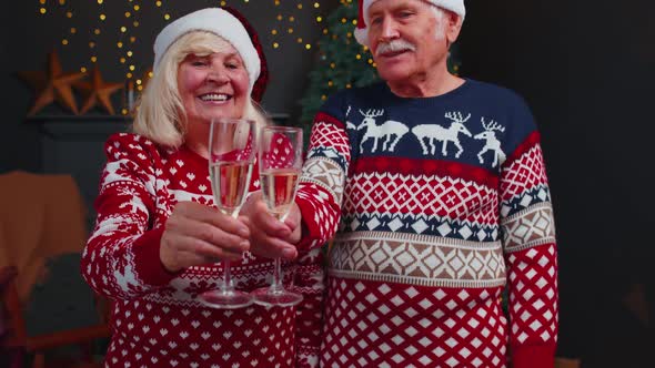 Joyful Senior Family Couple Celebrating Christmas at Home Clinking Glasses and Drinking Champagne alt