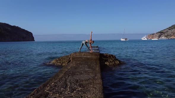 Unrecognizable woman doing yoga at seaside alt