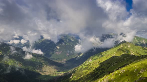View to green valley from Kasprowy Wierch in sunny day with clouds, Poland, timelapse, 4K alt