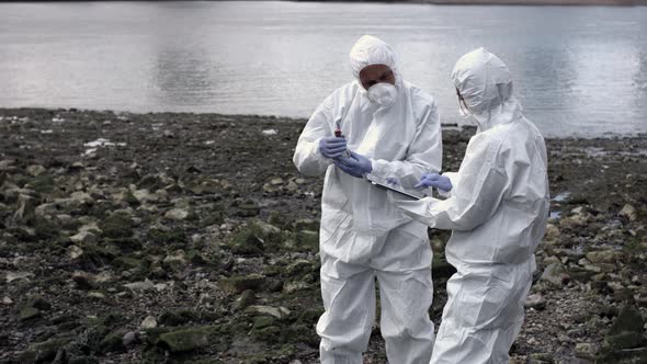 Forensic scientist examining sample at river bank