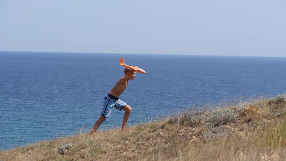 Boy with a Toy Airplane in His Hands on the Background of the Sea alt