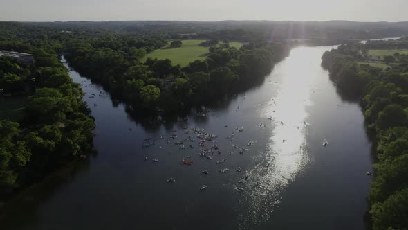 Aerial view over a group of SUP boarders on the Colorado river in Austin, USA - tilt, drone shot alt