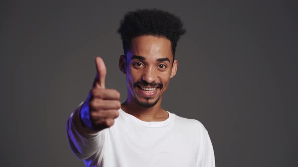 Young African Handsome Man Making Thumbs Up Sign Over Grey Background alt