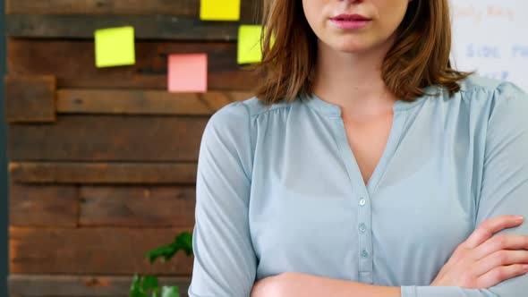 Portrait of business executive standing with arms crossed alt