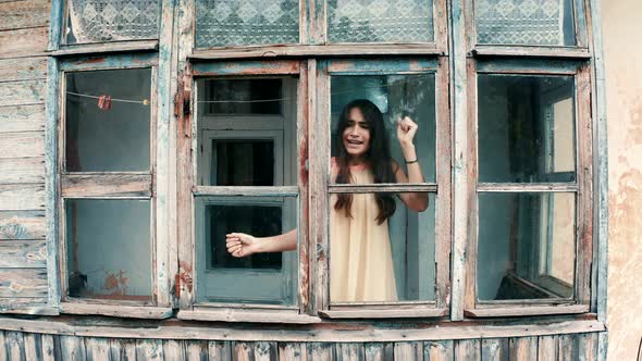 The locked girl in hysterics knocks on the glass with her hands and calls for help alt