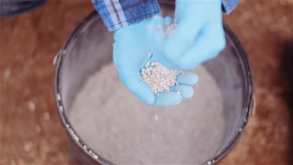 Farmer Examining Herbicides Fertilizer in Hands Before Fertilizing Agriculture Field alt