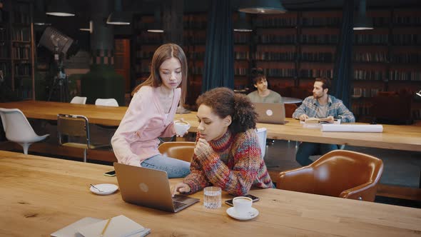 Young Black Female Worker Solve Problem with Help of Colleague alt