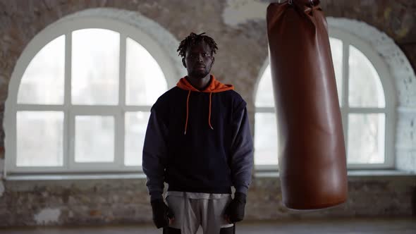 African American Boxer with Boxing Pear on Background Standing Looking to the Camera alt