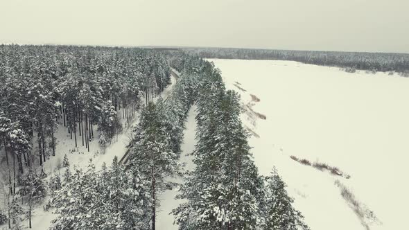 Beautiful Winter Landscape with Forest Lake and Road Aerial View alt