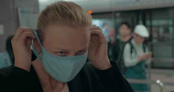 Young Blond Woman Wearing Surgical Mask in metro. Wuhan, China alt