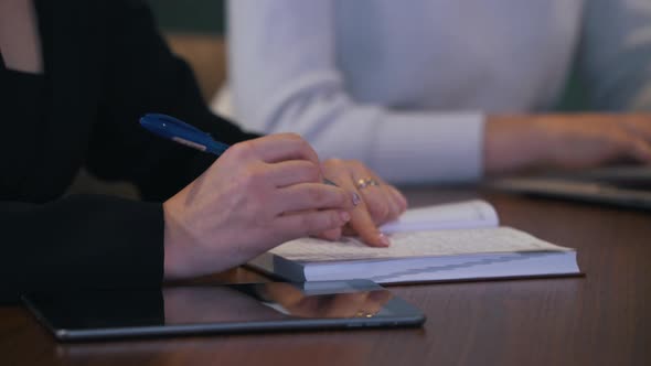Girl Writes Information in a Notebook During Negotiations alt