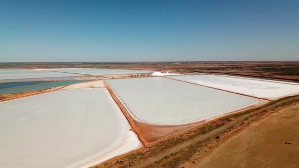 Aerial footage large Australian salt mine, arid landscape, drone circles right-left alt